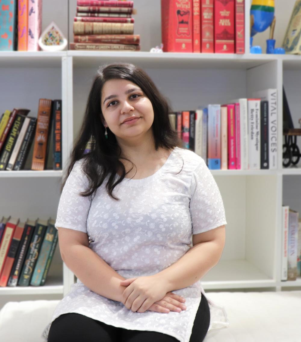 Rachita Sharma in front of bookshelves
